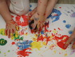 © Dilya - Mom plays with children, funny baby shows his palms painted with paint. Creative art classes. Laughter. Happy children and mom finger painting on paper at home. Bright colors, gouache and watercolors
