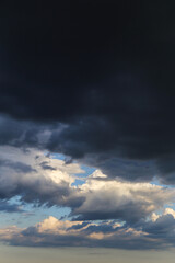 Wall Mural - Epic Dramatic storm dark grey cumulus rain clouds against blue sky background texture, thunderstorm