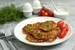 © New Africa - Delicious potato pancakes with fresh tomatoes served on grey table