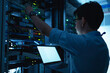 © reewungjunerr - Computer engineer is setting up network in server room,Systems Maintenance Technician,Male engineer working in server room at modern data center