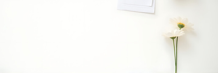 Poster - Simple home office setup features a desk with a notepad and a single flower on a clean white background._00002_