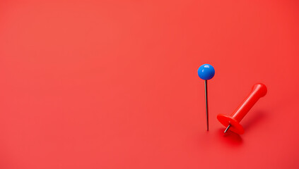 Poster - A small group of a pin and thumbtack sits on a red desk with plenty of space for text overlay._00003_