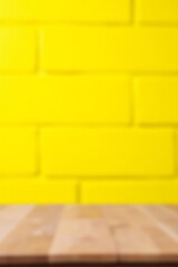 Aufkleber - A selective focus on an empty wooden table top against a bright yellow brick wall background is created visually._00003_