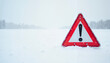 © Natalya - Red warning sign with exclamation mark in a snowy landscape with copy space
