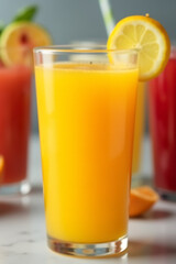 Poster - A brightly colored glass of orange juice is placed in front of a blurred background of various other fruit drinks._00002_
