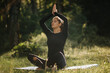 Pretty woman practicing yoga outside in a park at sunny day