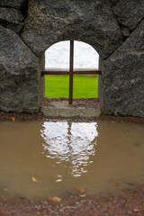 Wall Mural - Small arched window in a stone wall.