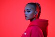 © Leo Rohmann - Bold portrait of a young woman with braided hair wearing a red hoodie against a vibrant crimson backdrop showcasing confident attitude and sharp details with edgy lighting effects