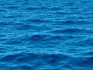 Smooth deep blue waves rippling on the surface of the sea, creating a mesmerizing texture, backdrop, sea, background