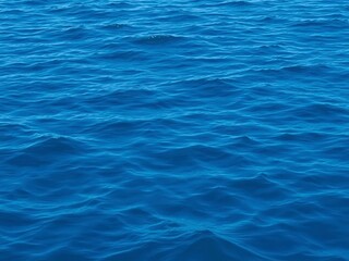 Smooth deep blue waves rippling on the surface of the sea, creating a mesmerizing texture, waves, surface