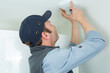 © auremar - technician installing smoke detector on ceiling wall