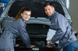 © auremar - mechanic with female apprentice by car with bonnet raised