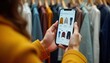 © miss irine - Person holds smartphone showing online clothing store app. Person browses fashion items. Clothes displayed on screen. Person looks at recommendations. Possible purchase of garments. Modern shopping.