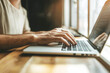 © Carmen - Close up side view of Caucasian man's hands typing on open laptop, home office with natural light
