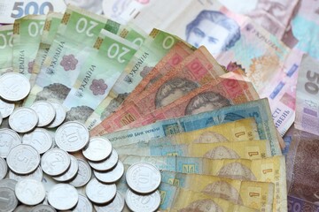 Ukraine money coins lying on mixed hryvnia banknotes, background.