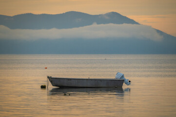 Wall Mural - Small boat anchored in a quiet bay in the San Juan Islands during a beautiful sunset. The Salish Sea provides endless places to anchor out an explore remote islands and hidden bays and coves.