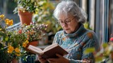 Serene Senior Reading: An elderly woman with silver hair, wearing glasses and a teal sweater, enjoys a quiet moment reading a book amidst a vibrant balcony garden.