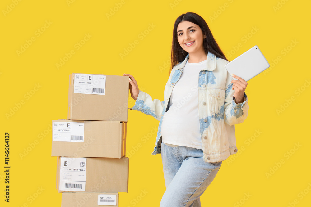 Pregnant online store seller with tablet computer and parcel boxes on yellow background