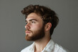 © Ranju - Portrait of a handsome man with a beard, wearing a white shirt, side view, isolated on a gray background with copy space