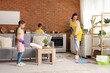 © Pixel-Shot - Cute little children helping their mother with cleaning routine at home