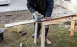 © schankz - A man is using a saw to cut a piece of wood