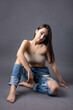 © Mountains Hunter - A beautiful brunette poses in the studio wearing a top and jeans.