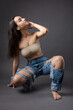 © Mountains Hunter - A beautiful brunette poses in the studio wearing a top and jeans.