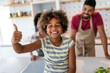 © NDABCREATIVITY - Happy african american family preparing healthy food in kitchen, having fun together on weekend