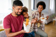 © NDABCREATIVITY - Happy african family eating at living room and enjoying time together. Home delivary takeaway food