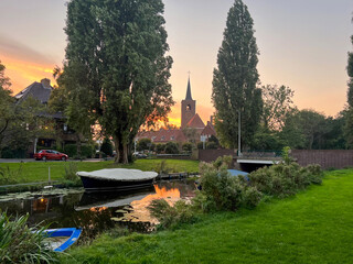 Wall Mural - picturesque view of canal with moored boats on sunset