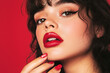 © Anastasiya - Portrait of young brunette woman with makeup, red lips on red background. Beauty, cosmetics concept