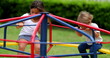 © Marco - Children playing at playground caroussel. Kids spinning around outdoors