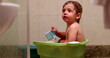 © Marco - Toddler boy inside bucket taking a bath. Baby bathtub