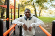 © Marko Geber - Senior man working out with headphones at a park