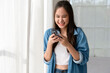 © tonefotografia - Young Asian woman enjoy using smartphone at home