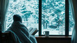 © GustavsMD - Cozy Winter Scene: Person Reading by the Window with Snowy Forest View and Warm Blanket