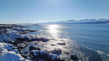Poster - Scenic winter landscape featuring a snowy shoreline and a bridge over a shimmering sea.