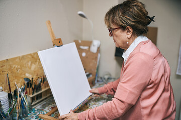 Wall Mural - Senior woman preparing canvas for painting