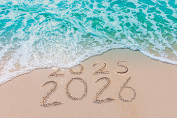 Wall Mural - message year 2025 replaced by 2026 text written on beach sand background. good bye 2025 - 2026 happy