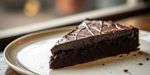 Poster - A single slice of rich chocolate cake with a smooth, dark chocolate frosting, sitting on a white plate with crumbs scattered around it.