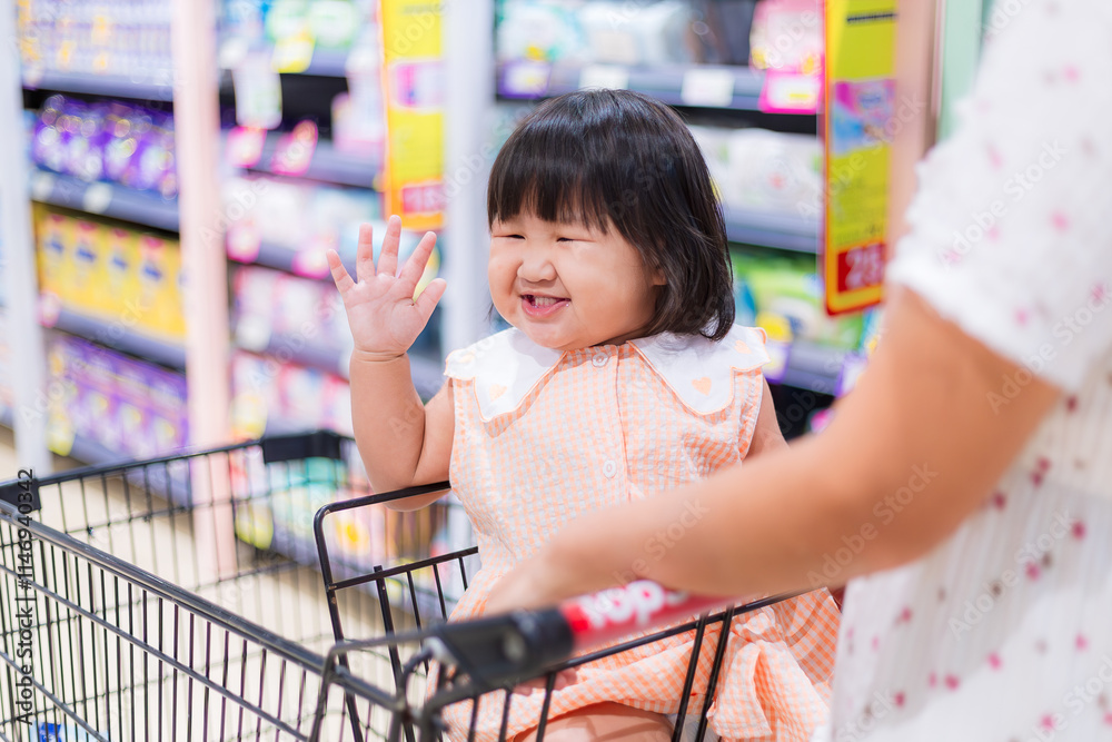 Cute girl sitting on a shopping cart in a shopping mall,Happy little ...