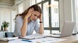 © engincan - woman working in office has headache and holds her head