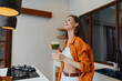 © SHOTPRIME STUDIO - Joyful young woman enjoying a healthy green smoothie in a bright kitchen, showcasing vibrant colors and a fresh lifestyle concept