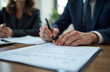 © annmelnikova - Male and female adults signing legal document in office setting