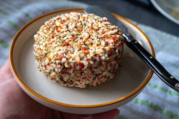 French cheese collection, fresh white soft goat cheese with aromatic herbs, garlic, parsley and red peppers close up