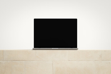 Wall Mural - opened laptop with a blank screen on the light brick podium