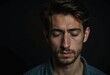 © Vibudhaart - A young man with his eyes closed, appearing thoughtful or melancholic against a dark background.