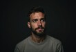 © Vibudhaart - A pensive man with a beard, gazing thoughtfully into the distance against a dark background.