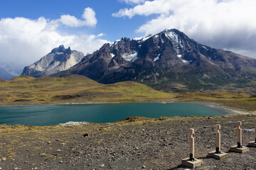 Laguna con aguas color turquesa, montañas con nieve bajo un cielo azul con nubes, en Parque Nacional Torres del Paine, Patagonia, Región de Magallanes y Antártica chilena, Chile