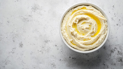 Wall Mural - Top view of creamy hummus in white bowl, homemade vegetarian mediterranean dip with copy space, healthy vegan food appetizer featuring chickpeas and tahini, delicious olive oil drizzle.